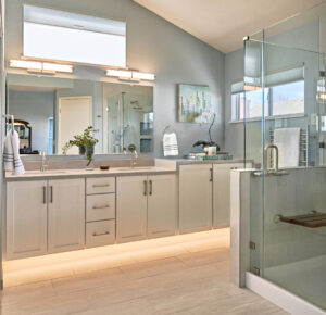 Master bath with white cabinets, blue paint and toe-kick lighting